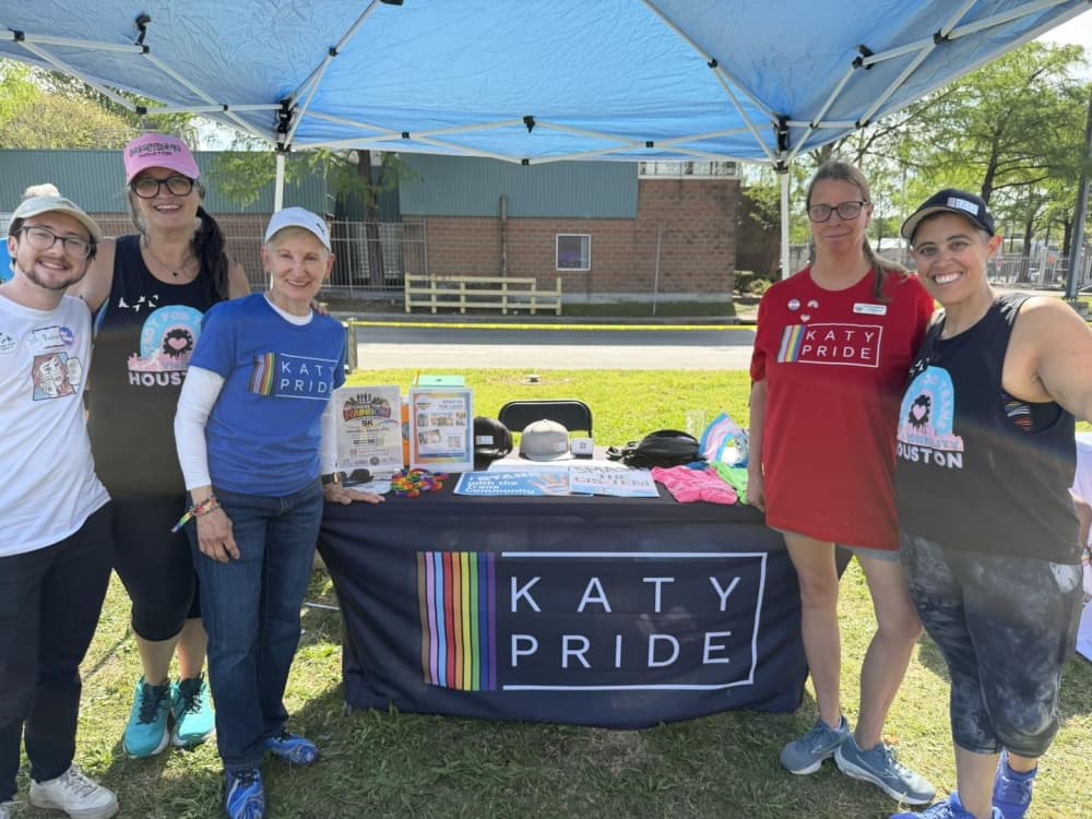 Five people around Katy Pride table.