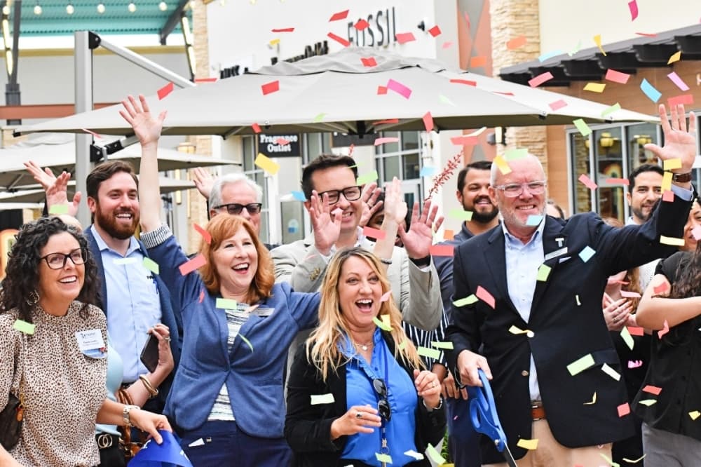 People celebrate at a ribbon-cutting ceremony