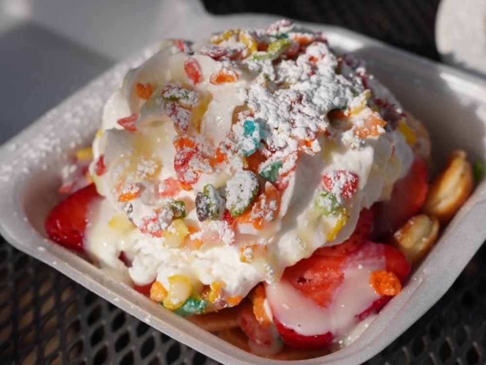 Mini pancakes topped with whipped cream and fruity pebbles cereal