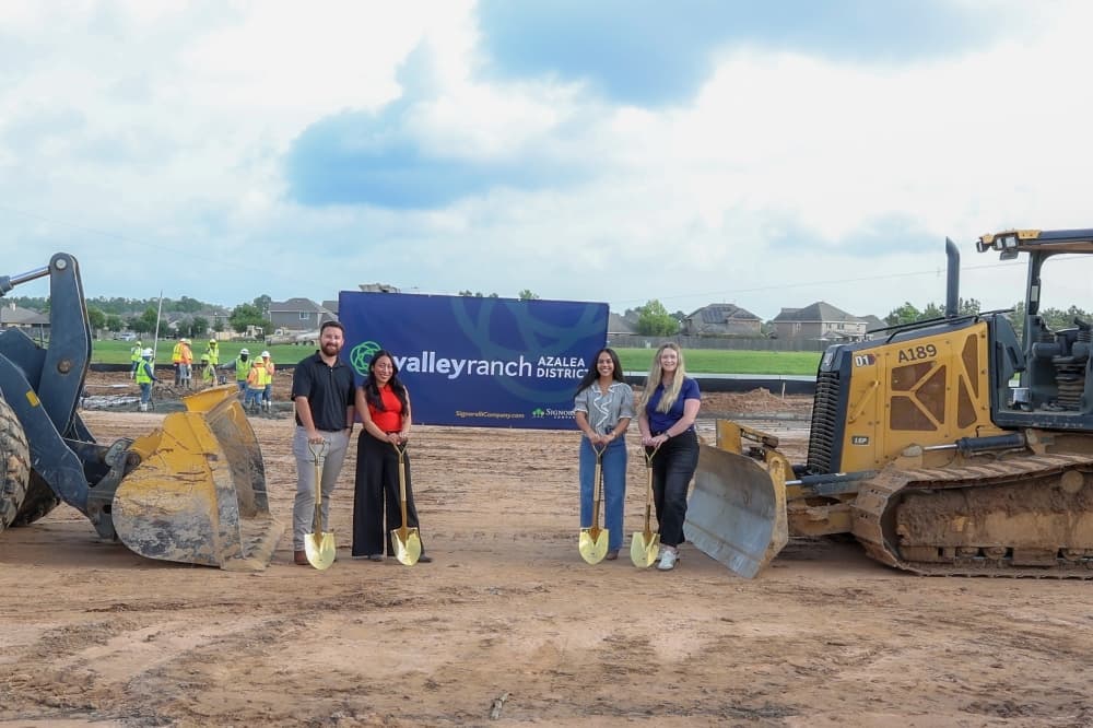 Employees of The Signorelli Company celebrate the groundbreaking of the Azalea District's single-family residential community in front of construction