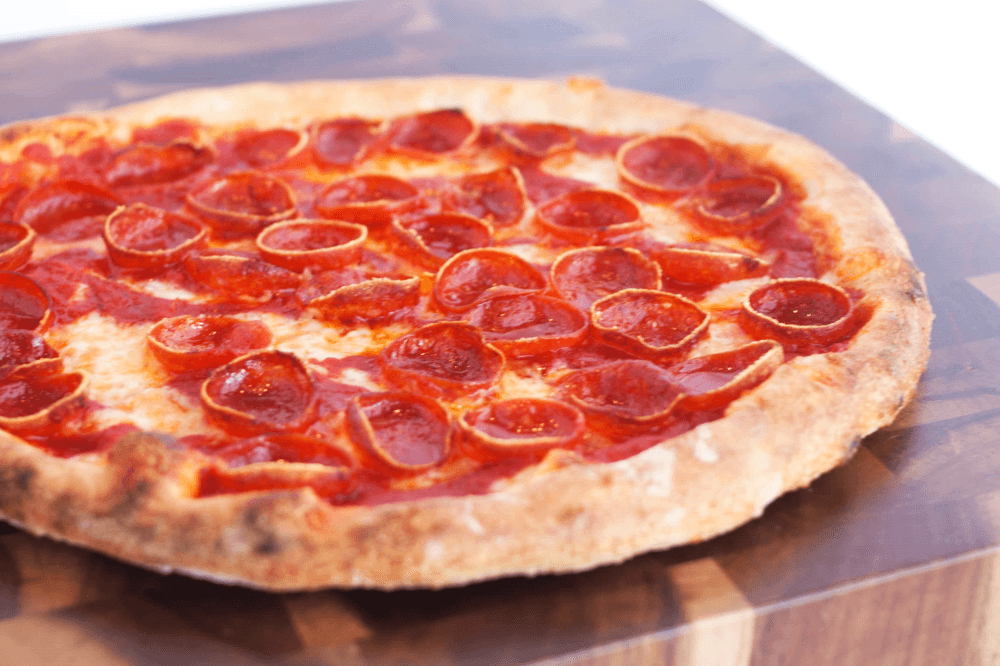 Pepperoni pizza from Blue Baker topped with melted mozzarella and house-made crust at a local artisan bakery and pizzeria in College Station near Texas A&M University