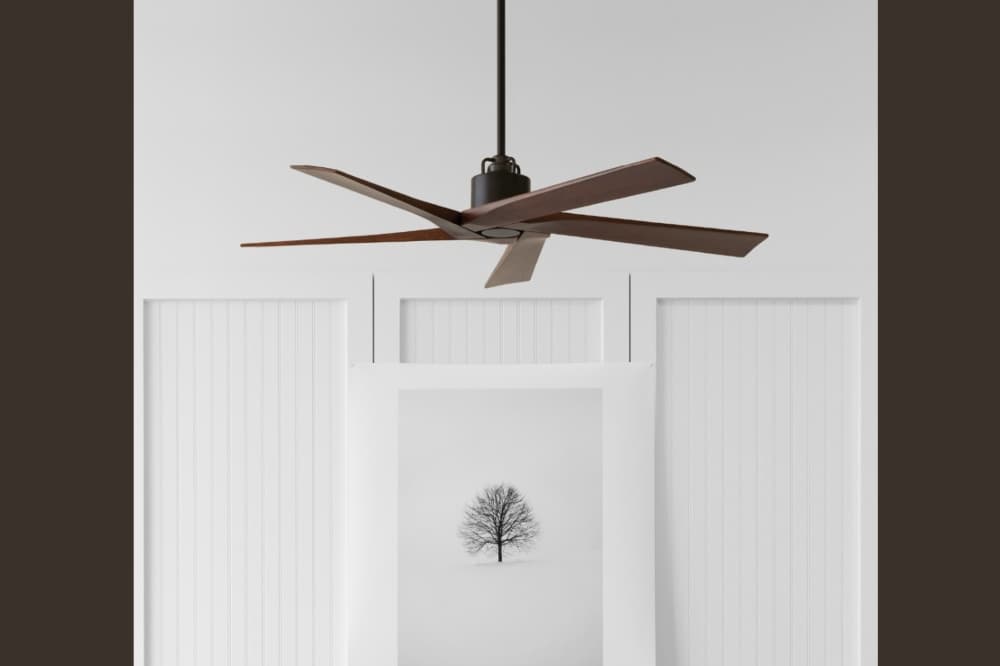 Modern dark wood ceiling fan with five blades on a minimalist white paneled wall.