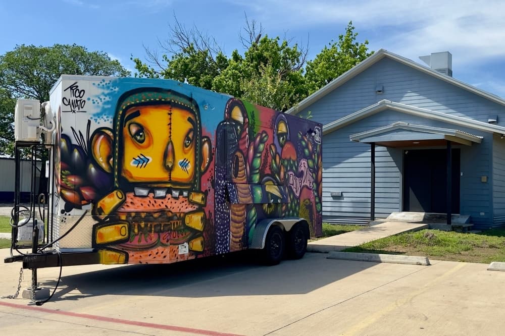 A brightly colored food truck is shown behind the building.