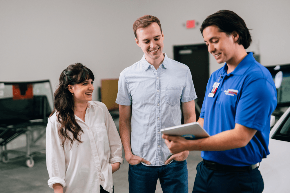 Family-owned auto glass shop team assisting customer with vehicle damage repair