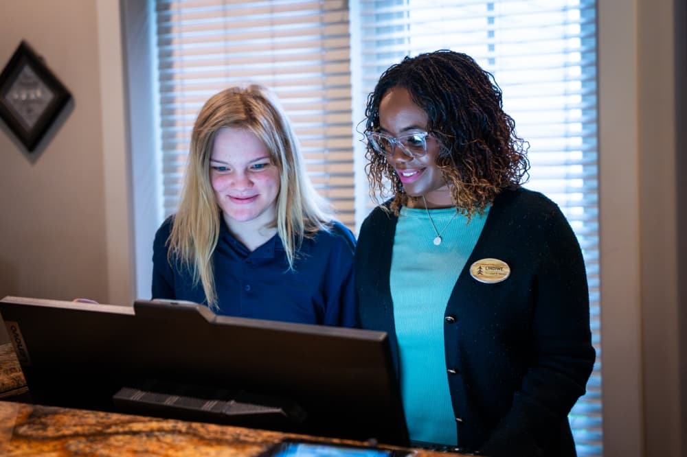 student working on computer with hyatt employee