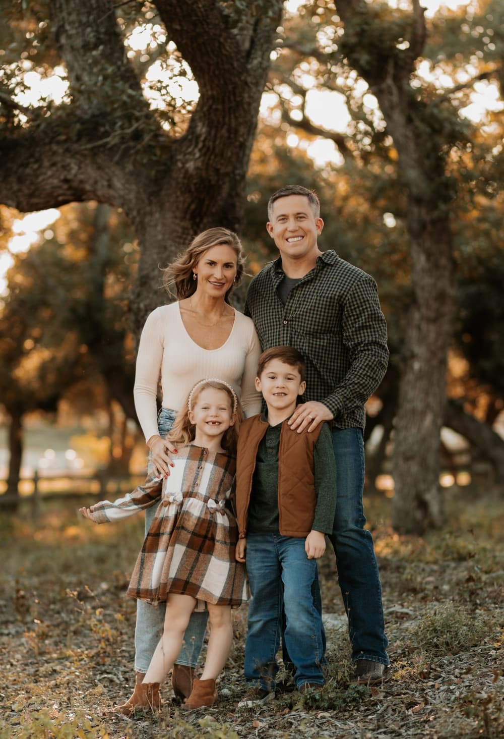 man and woman posing with children in the fall