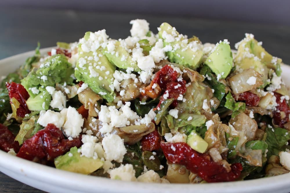 Green salad featuring cheese, tomatoes and more. 