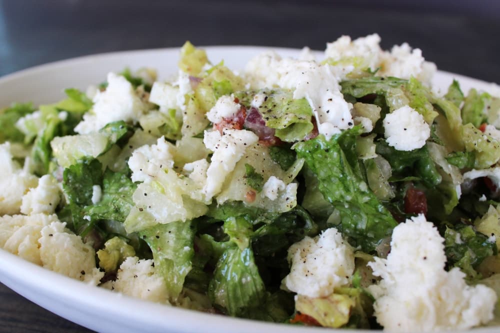 Green salad topped wit cheese and clear dressing. 