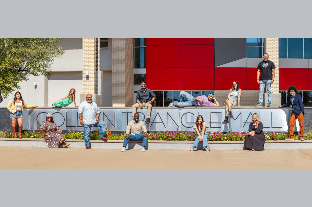 faces of denton in front of golden triangle mall sign