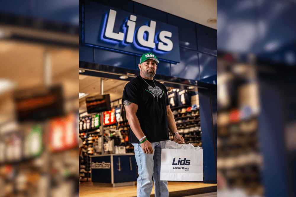 man in front of shoe store holding a bag