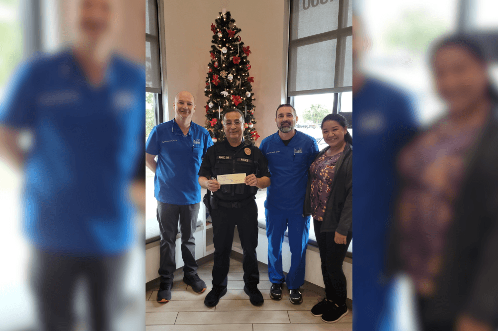 leander vet clinic team awarding a police officer a check