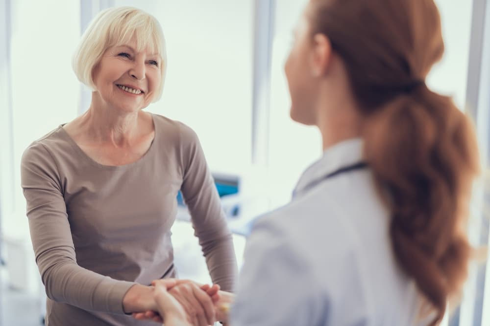 woman shaking doctor's hand and smiling