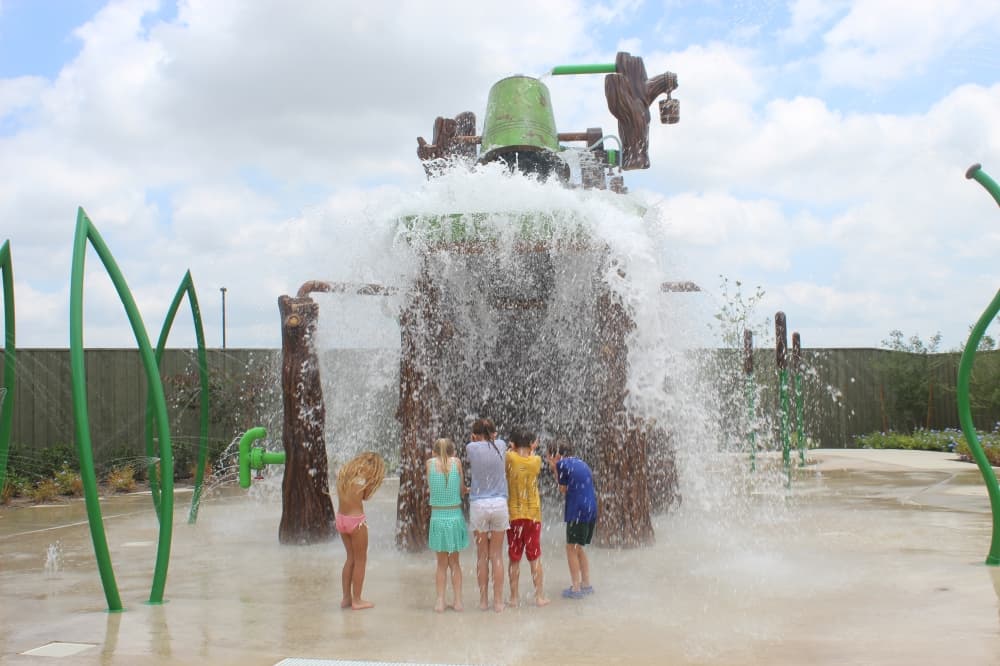 A bucket splashes down on kids at Shrek’s Swamp at Universal Kids Resort in Frisco on June 18. (Samantha Douty/Community Impact)