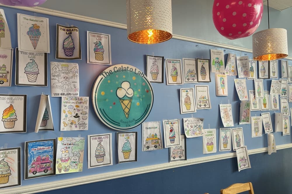 Coloring pages from past customers are posted on the shop wall. (Brooke Sjoberg/Community Impact)