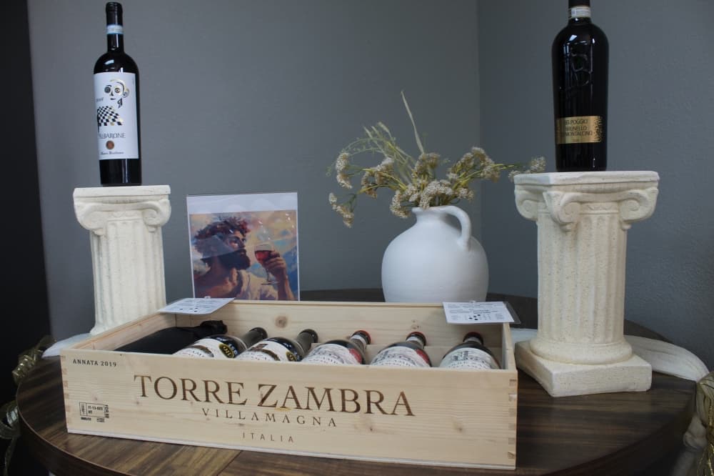 A display featuring Torre Zambra wine in a wooden box flanked by two Greco-Roman columns