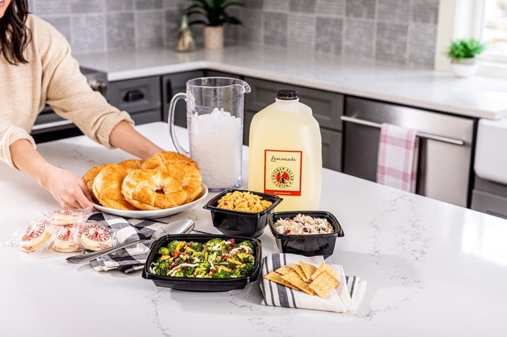 woman serving chicken salad with croissants