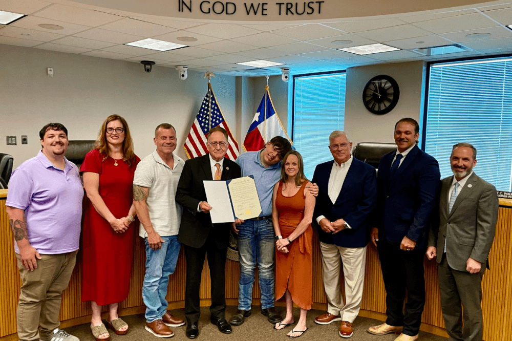 Jordan Dalton and his family take a photo with commissioners for his proclamation.
