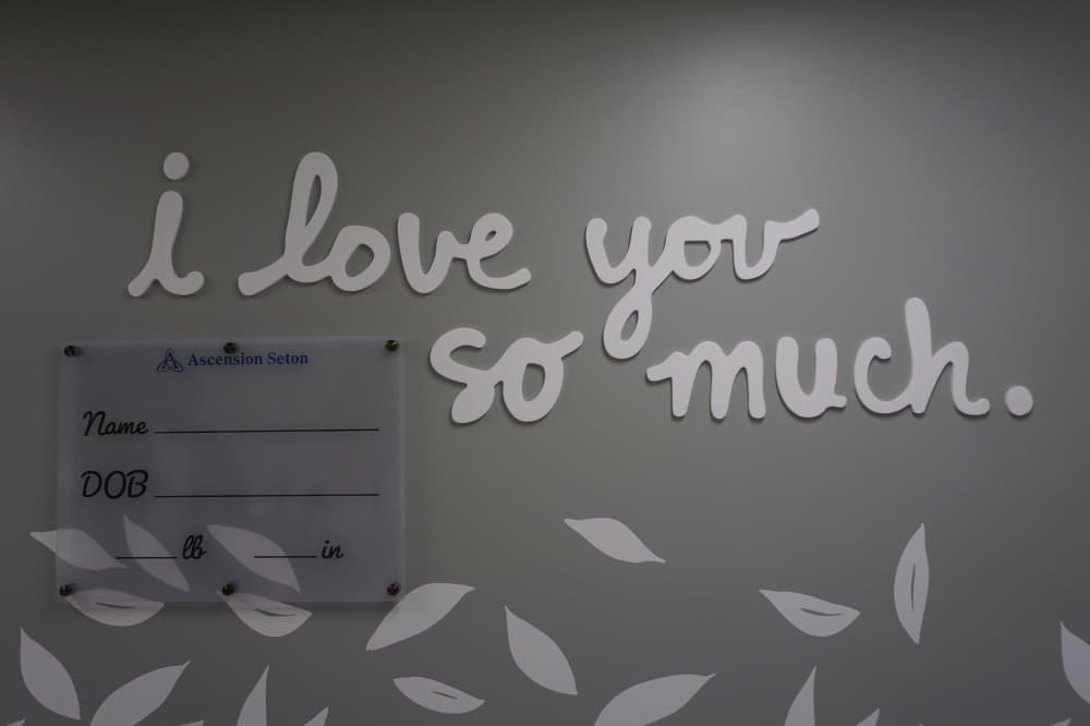 On the way to the nursery, families pass an Austin-themed mural inspired by the city's iconic "I love you so much" sign, where parents can write in their baby's name, birth date, height and weight for a keepsake photo. (Jessica McLaren/Community Impact)