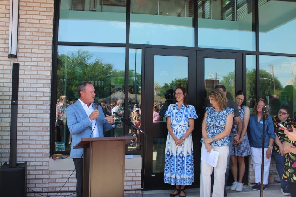 McKinney Mayor Bill Cox speaks during a ribbon cutting ceremony for the Hugs Cafe Inc. headquarters.