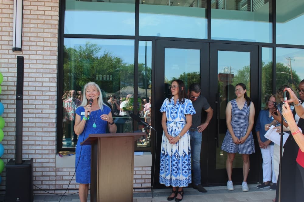 Hugs Cafe Founder Ruth Thompson speaks during a ribbon cutting ceremony for the nonprofit's new headquarters.