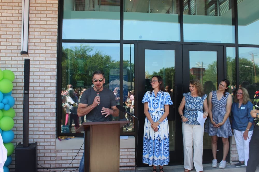 George Fuller, chairperson of the McKinney Community Development Corp. board of directors, speaks during a ribbon cutting ceremony for the new Hugs Cafe Inc. headquarters. 