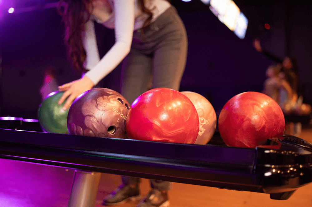 person picking up a bowling ball