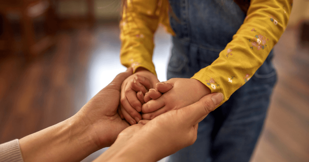 caregiver holding child's hand