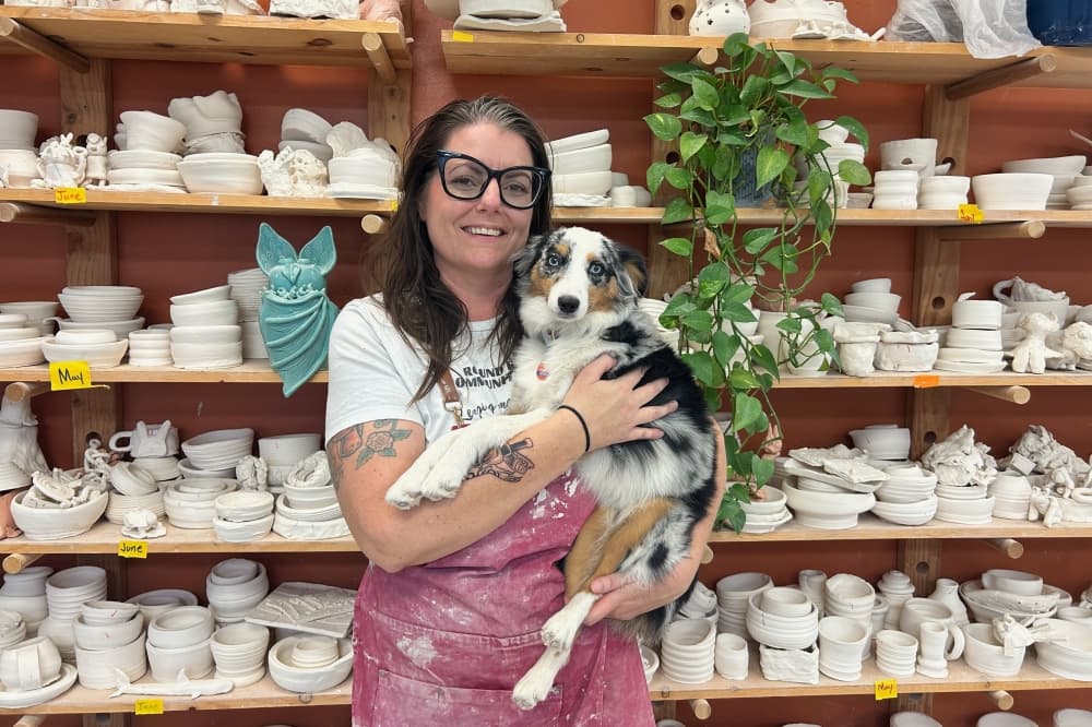 Round Rock Community Clay is locally owned by ceramicist Emily Adams, pictured with her dog, Roxie. (Brooke Sjoberg/Community Impact)