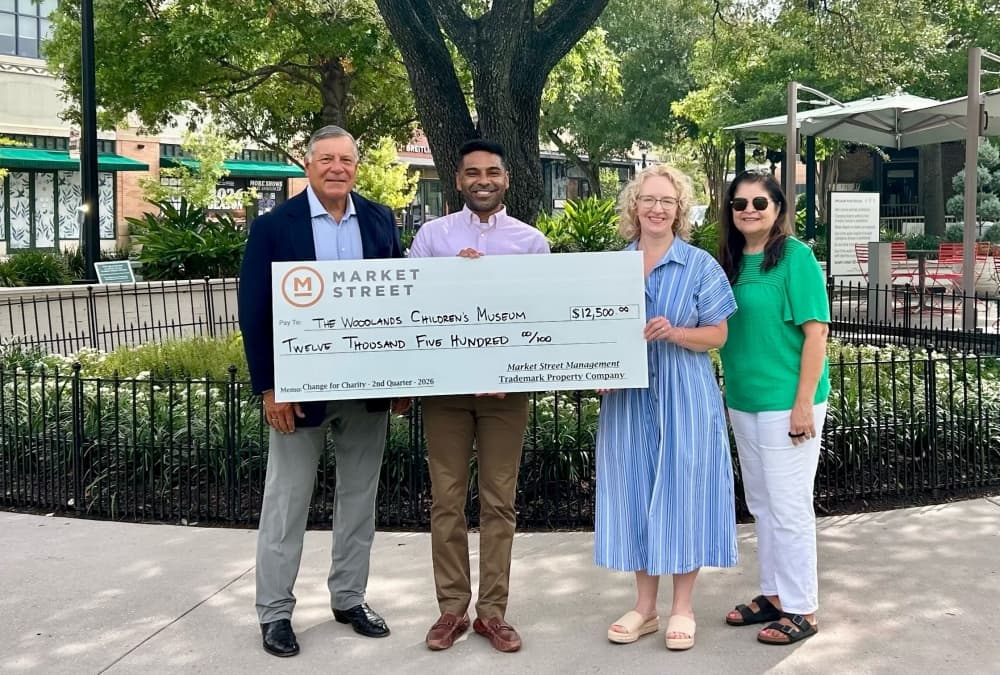 Four people stand with a check