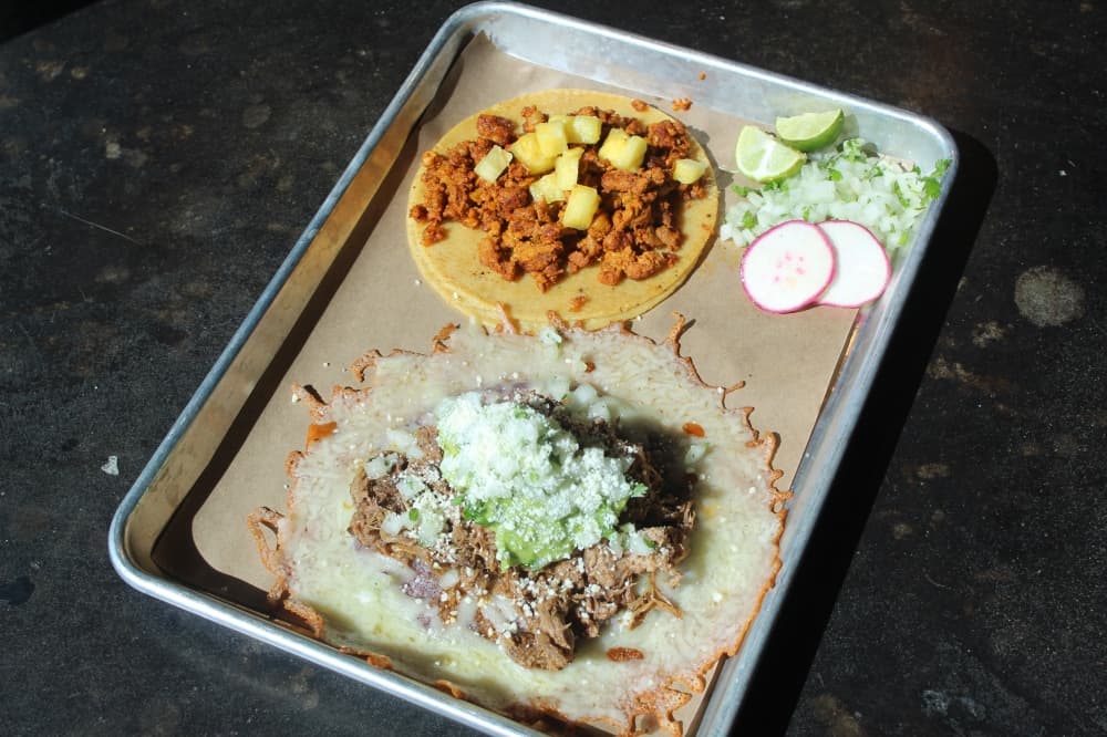 Two tacos on a metal tray
