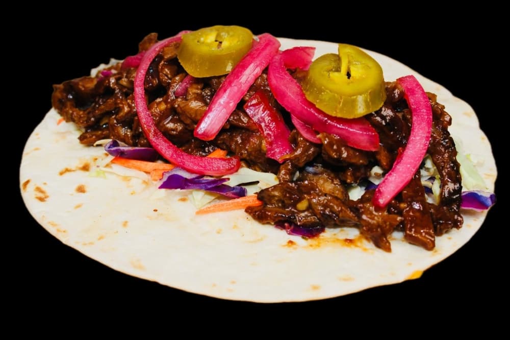 The beef brisket taco comes with brisket, pickled jalapeno, pickled onions, cilantro, a cheese blend and barbecue sauce.