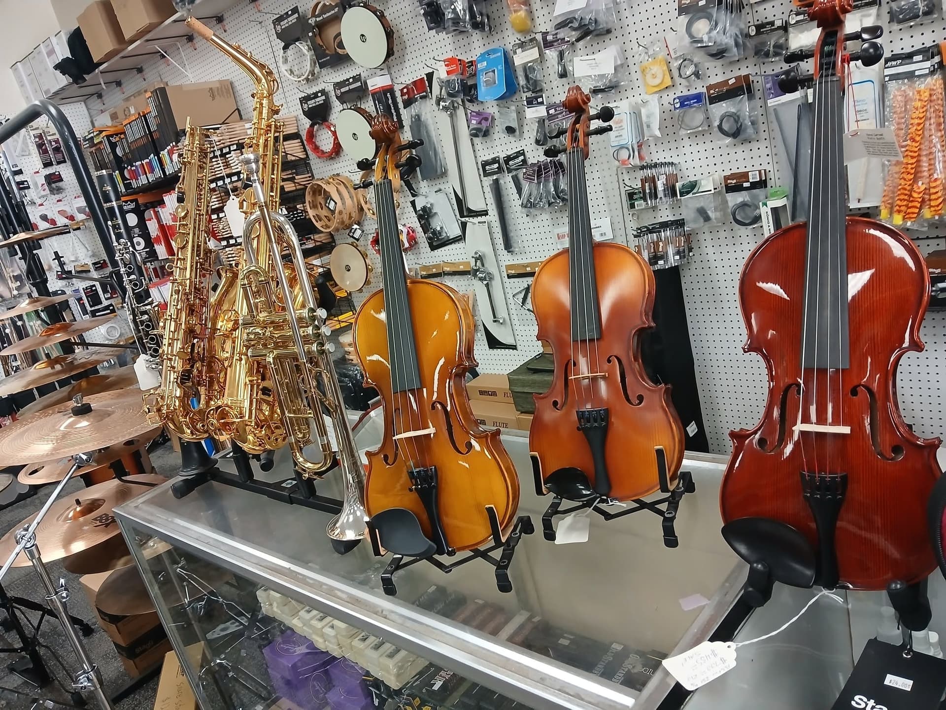 Counter with violins and saxophones displayed at Andrew's Music.