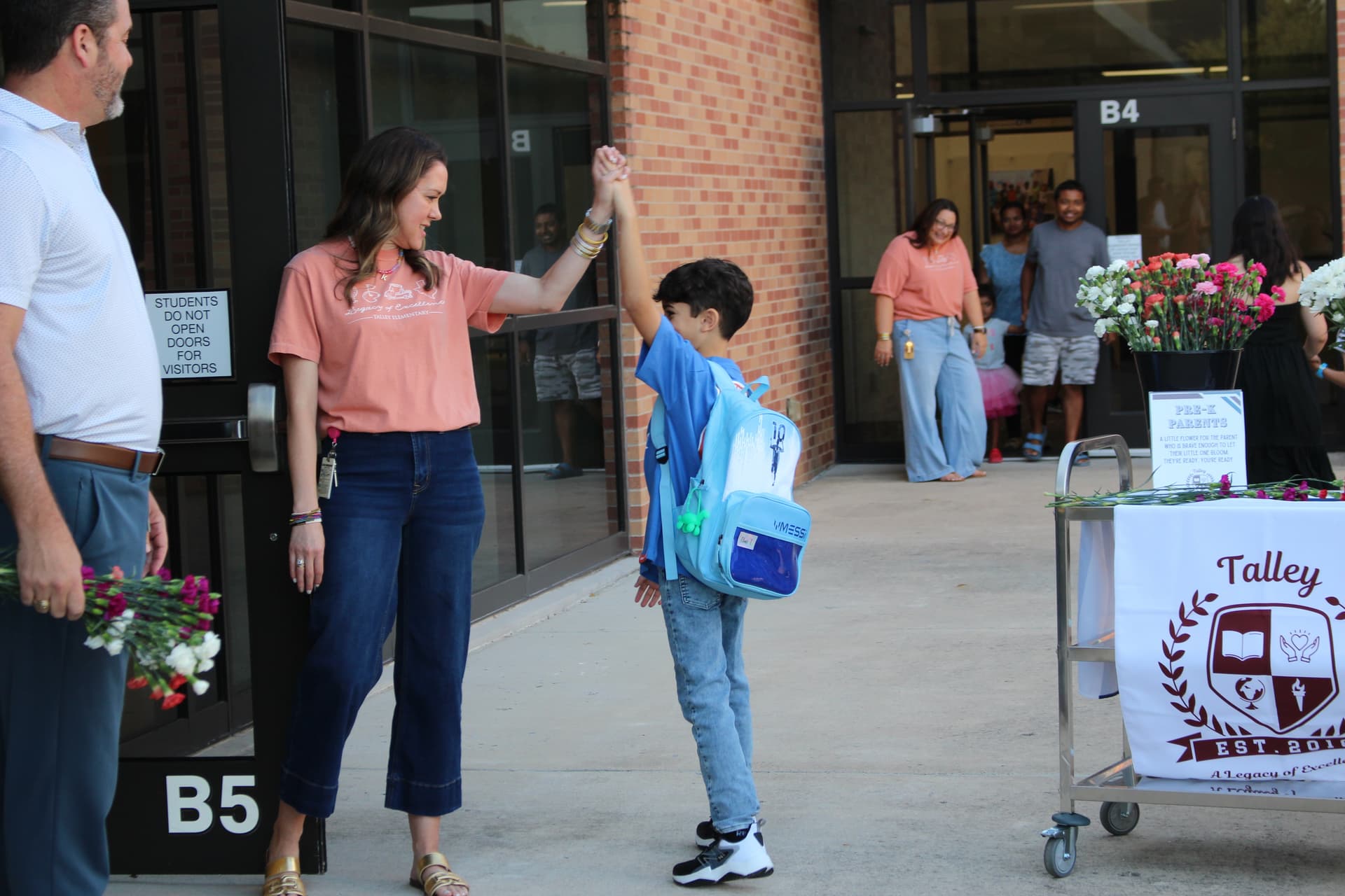 A staff member at Talley Elementary School high-fives a student on the first day of school on Aug. 12. (Samantha Douty/Community Impact)