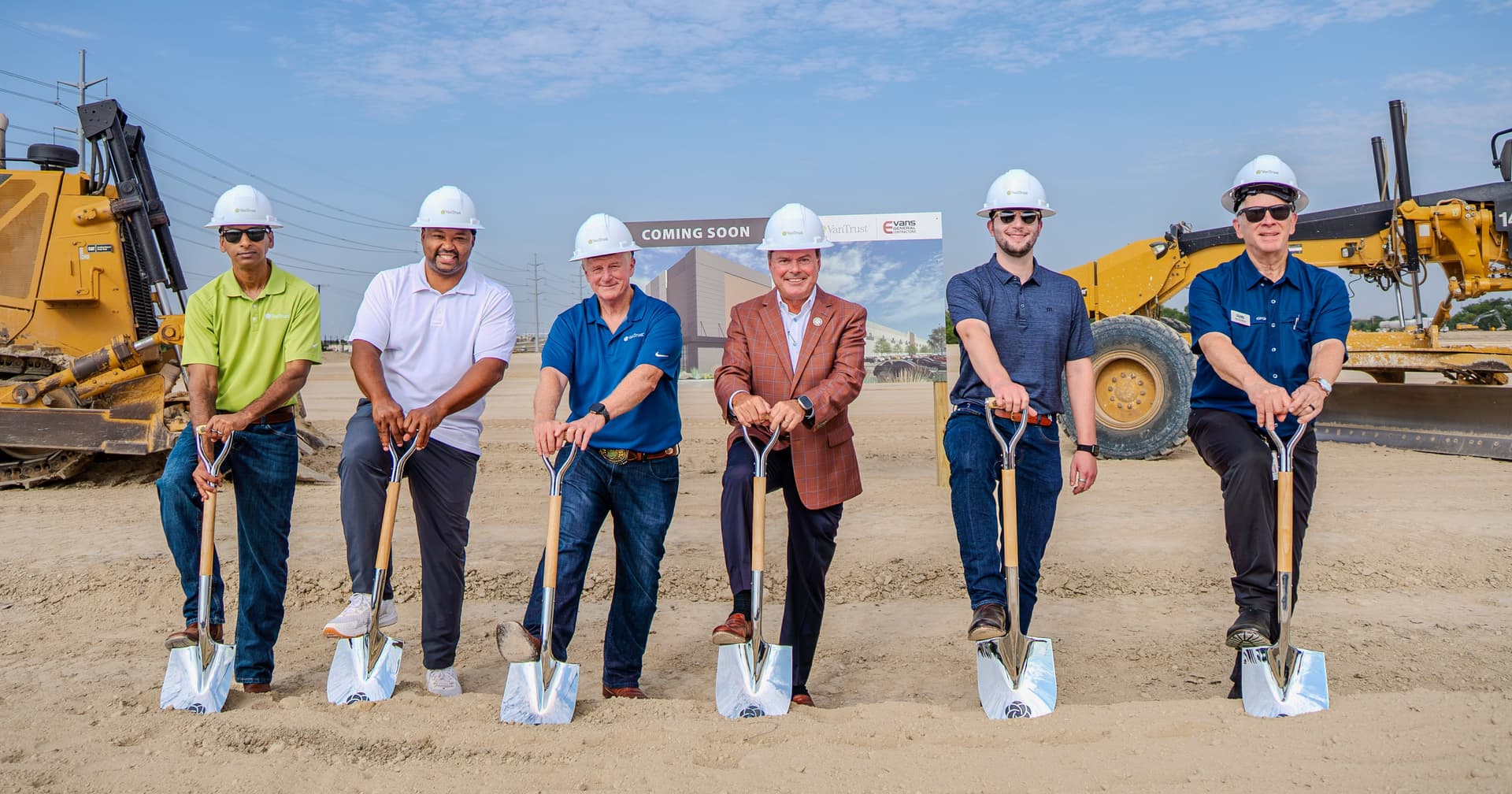 Line of people with shovels at a groundbreaking