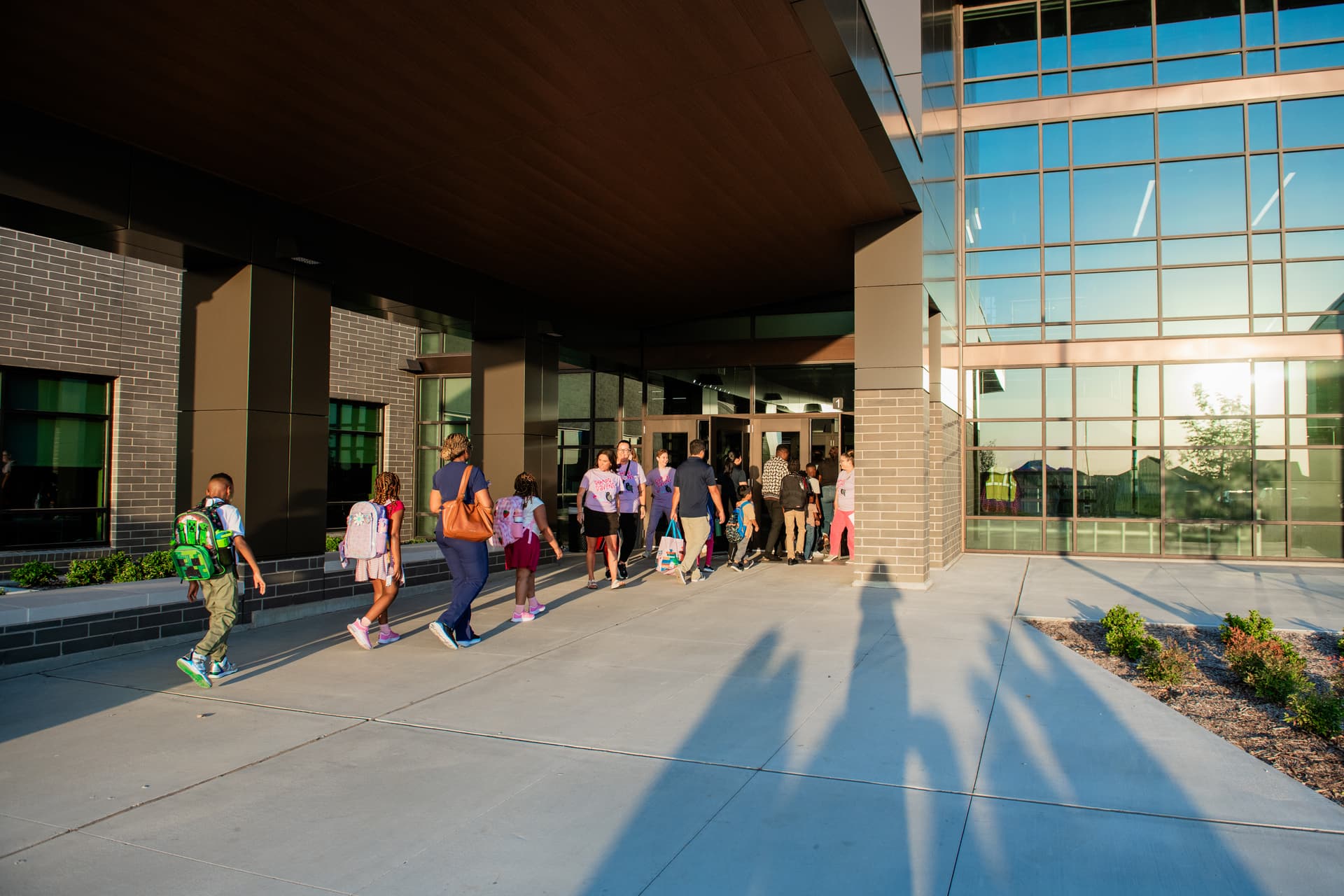 Parents walk with students through the front doors of Romer Elementary School on Aug. 12. (Sara Carpenter/Community Impact)