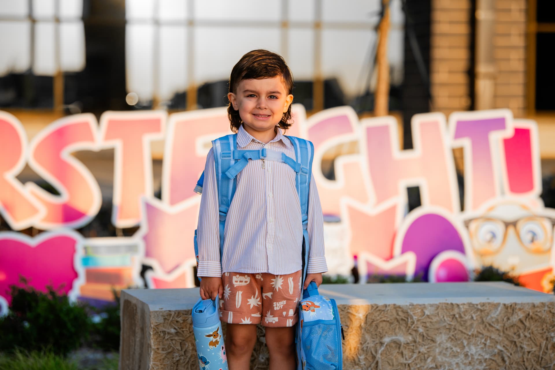 A child poses in front of celebratory signage at Romer Elementary for the first day of classes. (Sara Carpenter/Community Impact)