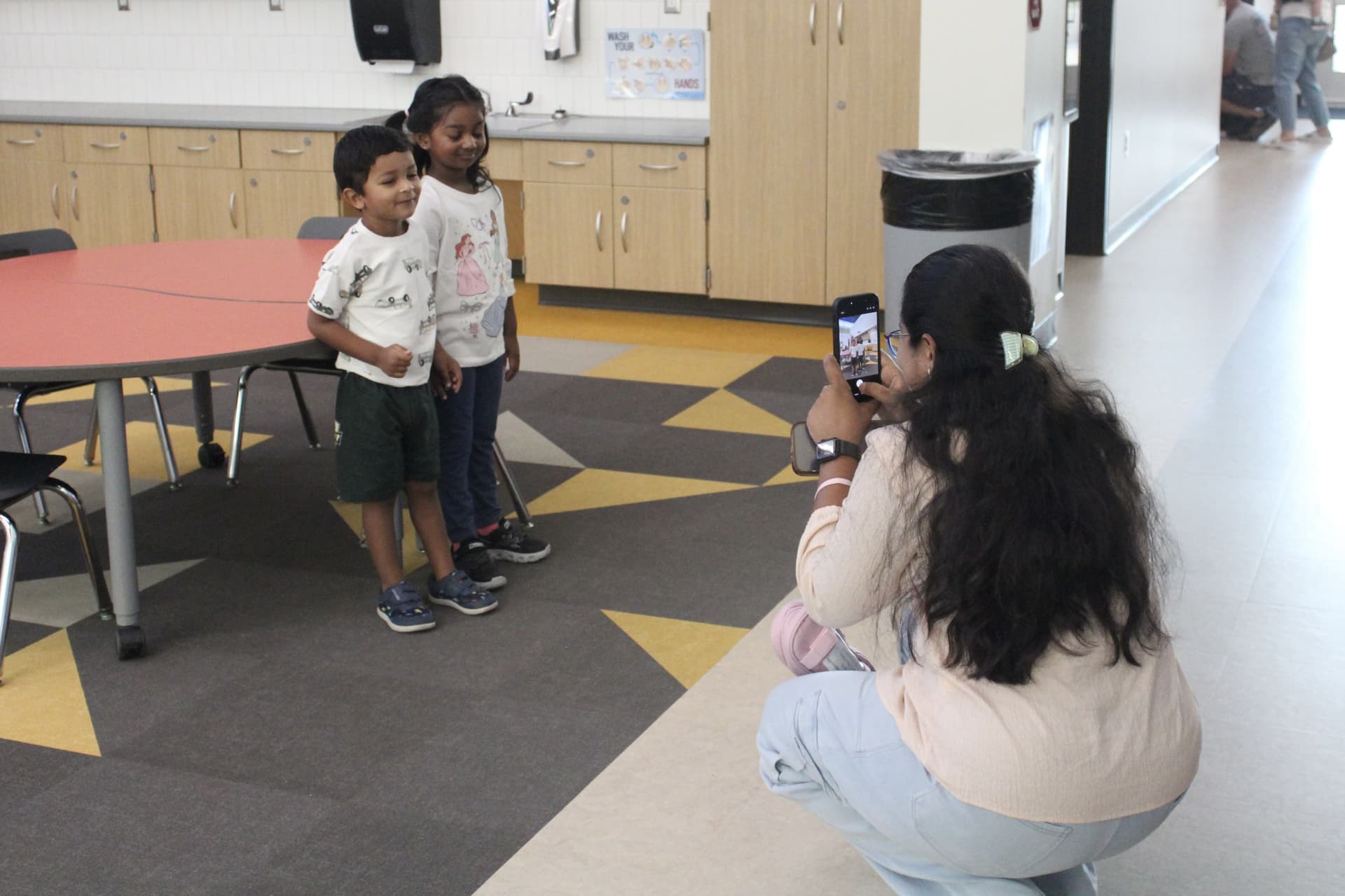 A parent takes a photo of her children on the first day of school at Carpenter Elementary School. (Jillian Nachtigal/Community Impact)