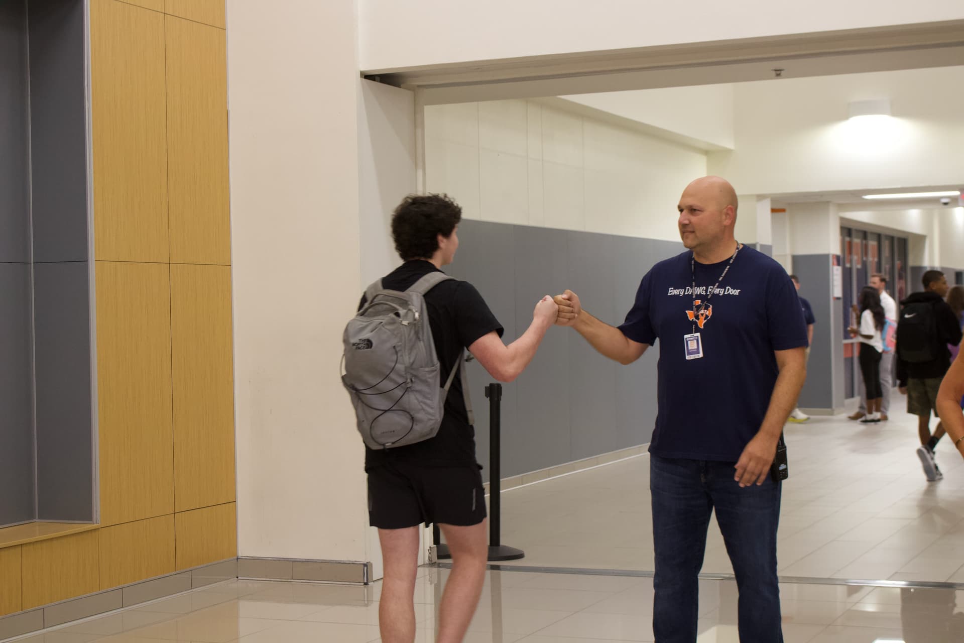 Justin Penio giving a student a fist bump
