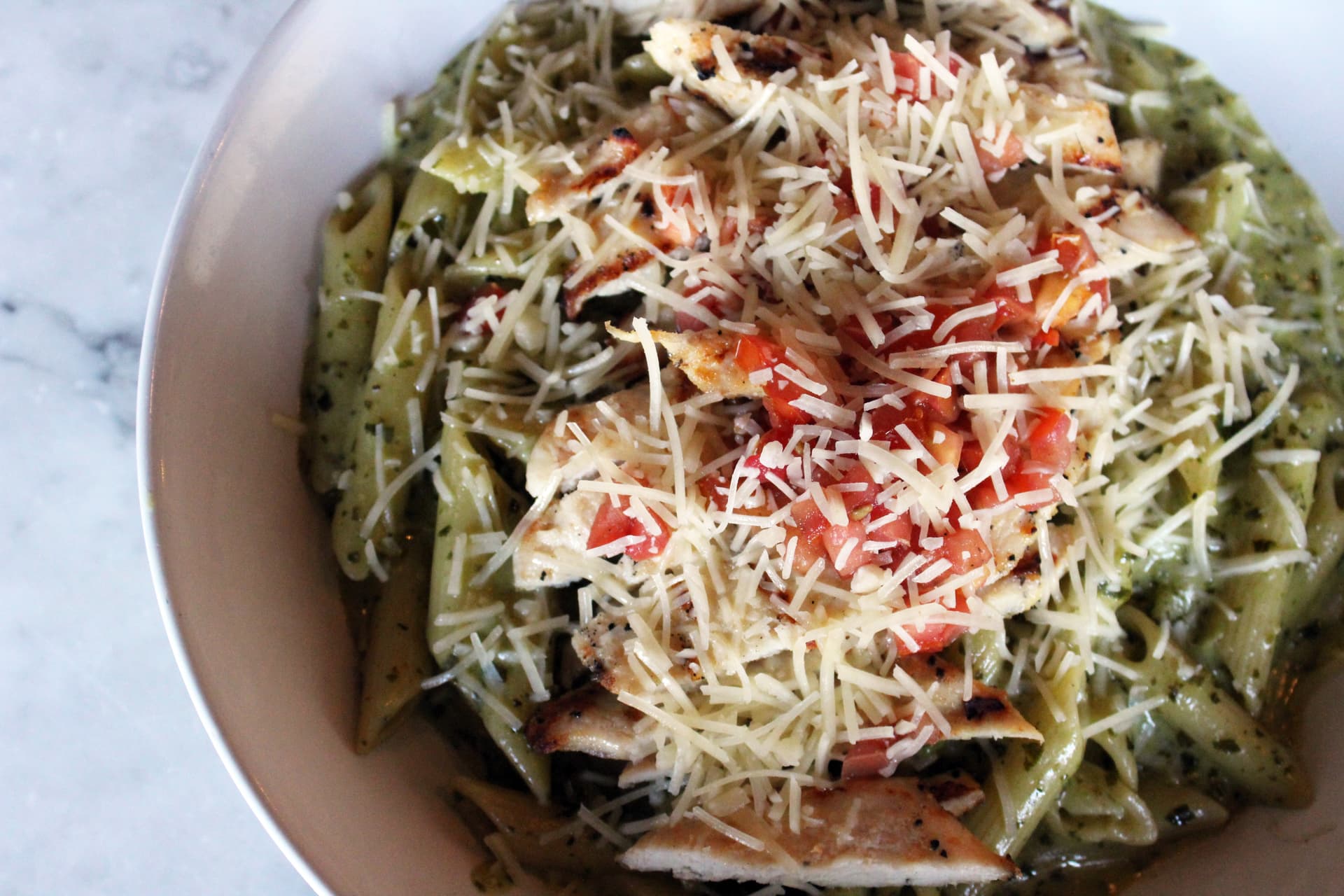 Grilled chicken penne pesto pasta ($29) features grilled chicken breast, penne, tomato, basil pesto and parmesan. (Karen Chaney/Community Impact)