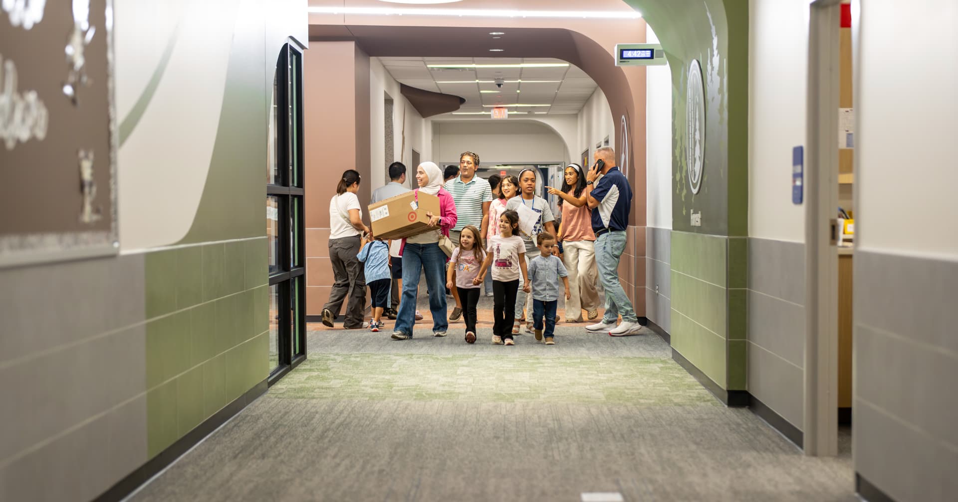 Allen ISD families walk down a hallway at Anderson Early Childhood School during a meet-the-teacher night. 