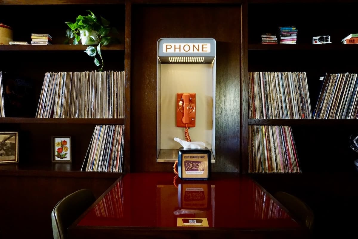 A portion of the restaurant is designed to feel like your best friend's basement, complete with an old telephone booth and vinyl records. (Sierra Martin/Community Impact)