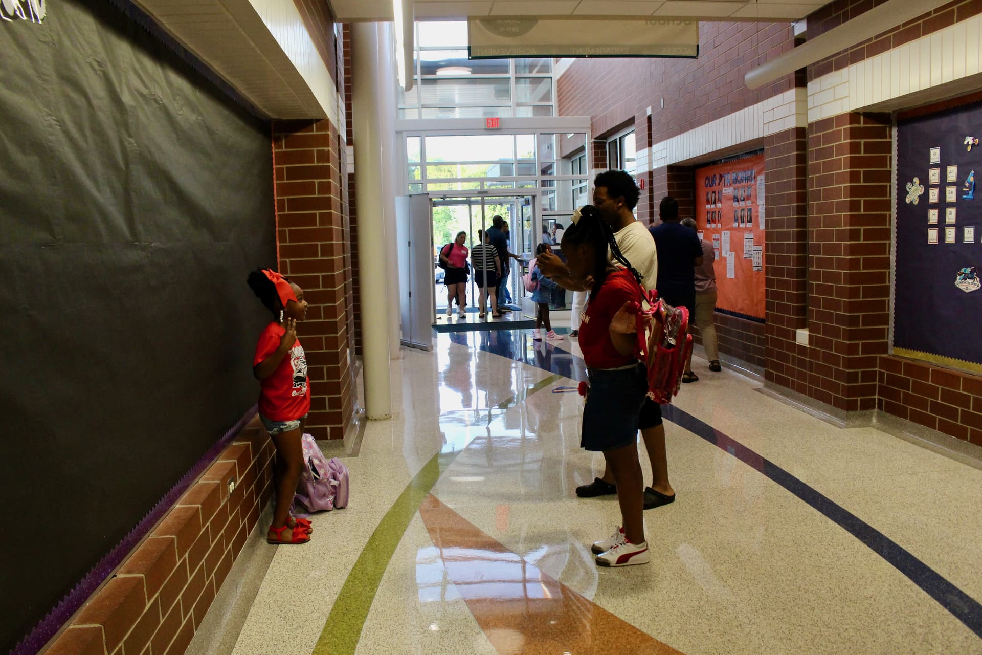 A parent takes photos of their students on the first day of school at Joe Lee Johnson Elementary School. (Brooke Sjoberg/Community Impact)