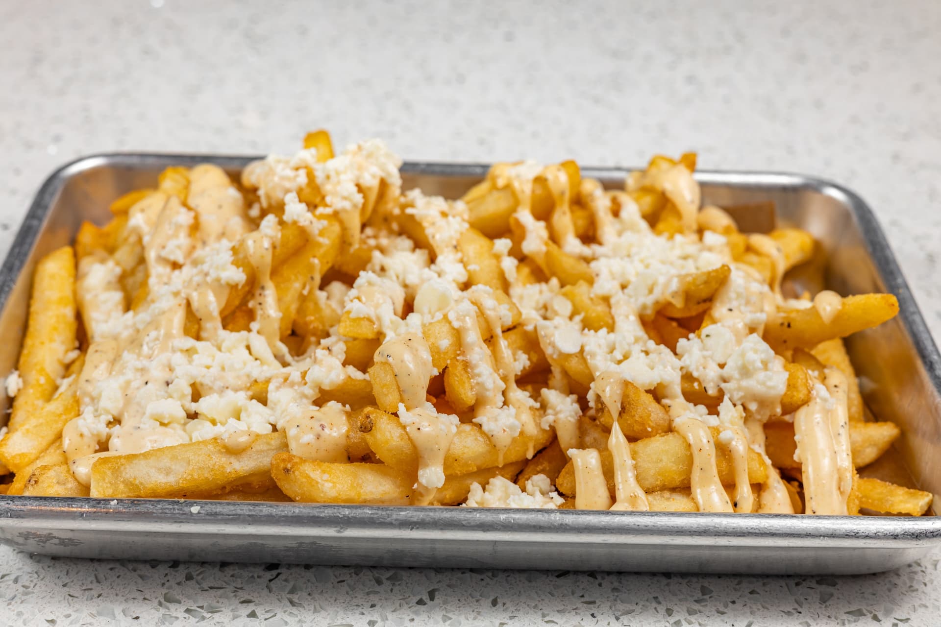 The restaurant's menu includes feta fries, which are regular French fries topped with feta cheese and house drizzle.