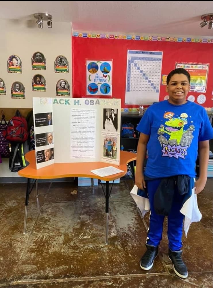 student alongside presentation in classroom
