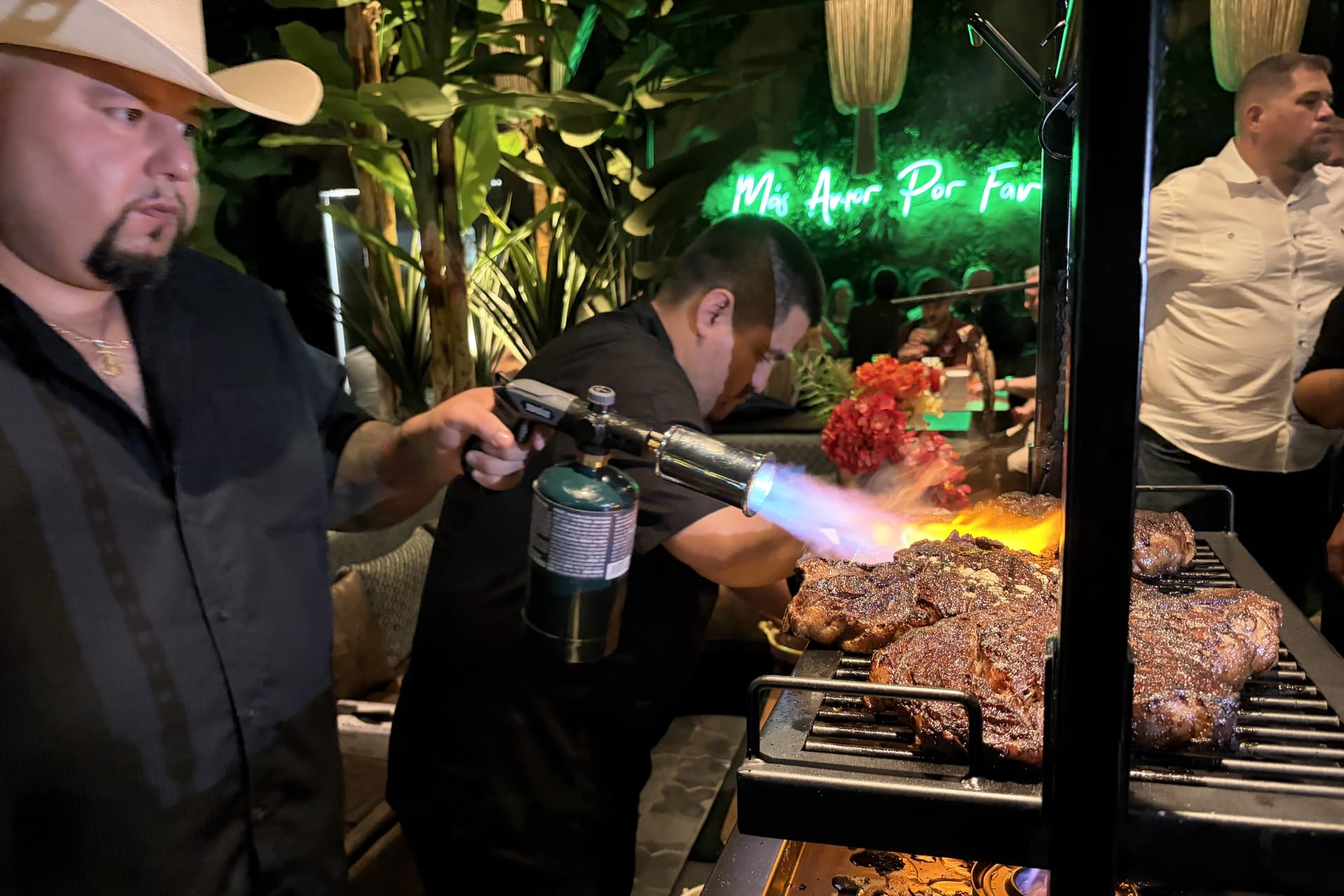 Individuals apply a blow torch on a meat dish during a Vidorra preview event Aug. 29. (Socrates Villarreal/Community Impact)