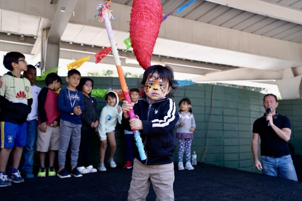 kid with piñata stick