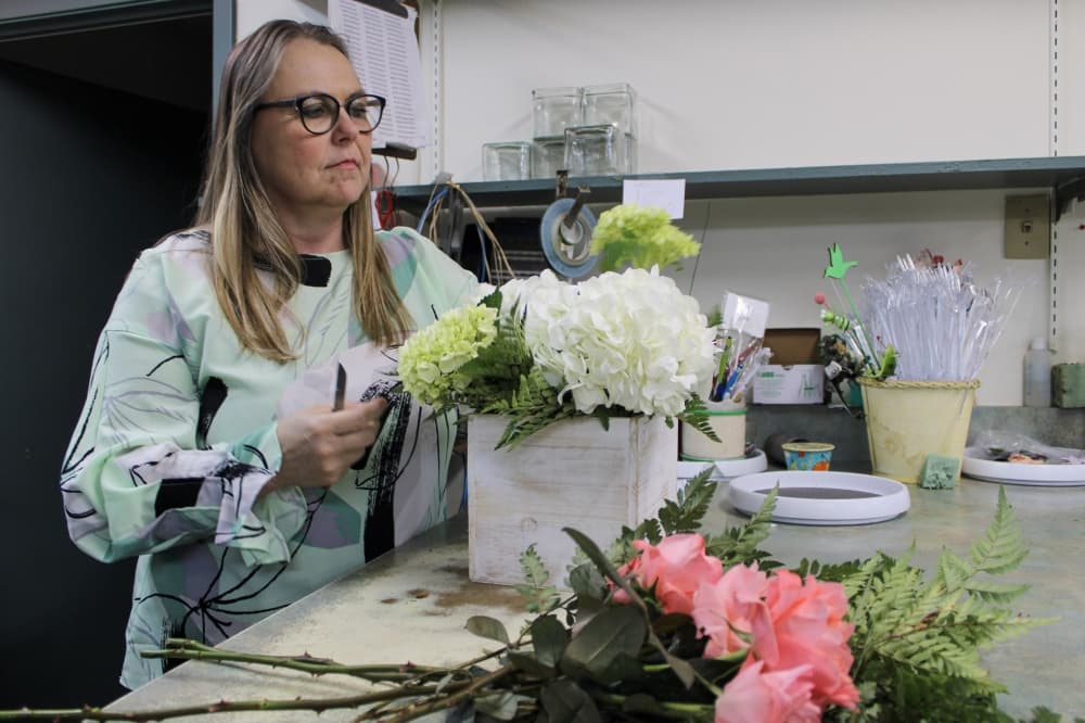An image of the co-owner of the business arranging flowers.