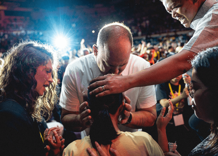 Preacher holds woman's head on a mission trip