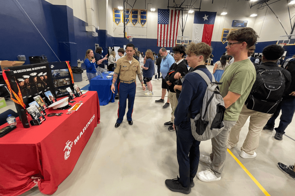 students listening to army members speaking