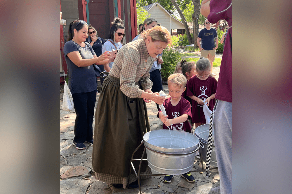 Volunteer guiding visitors through Heritage Farmstead historic farm buildings